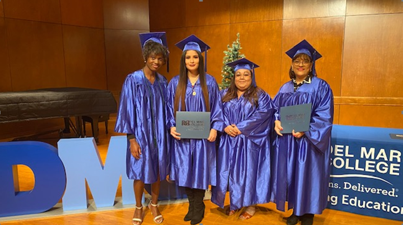 Four graduates with diplomas 