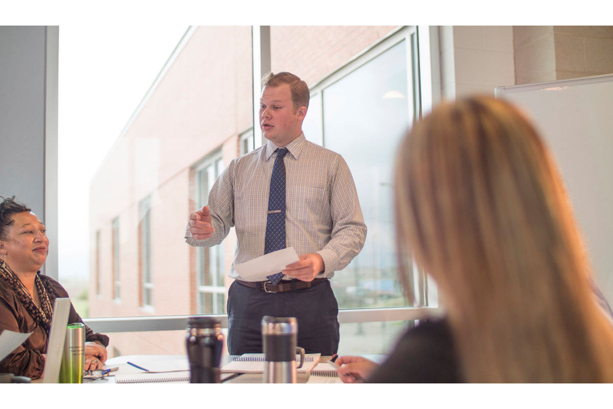 Business man speaks to a group of co-workers