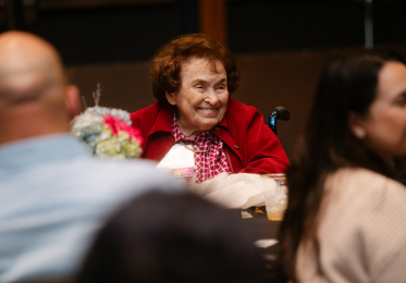 Camera focuses on a woman sitting at a table at a dinner