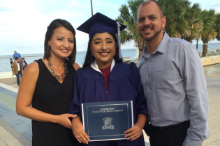 Micaela and her parents at her dmc graduation with Micaela in the middle