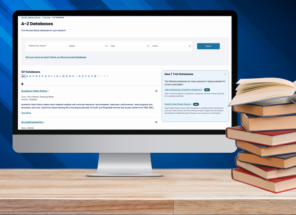 A computer screen with A to Z databases on the screen and a stack of books next to it
