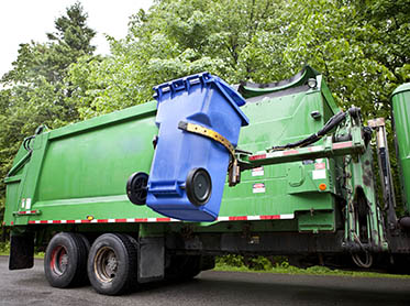 A garbage truck collecting a bin contents