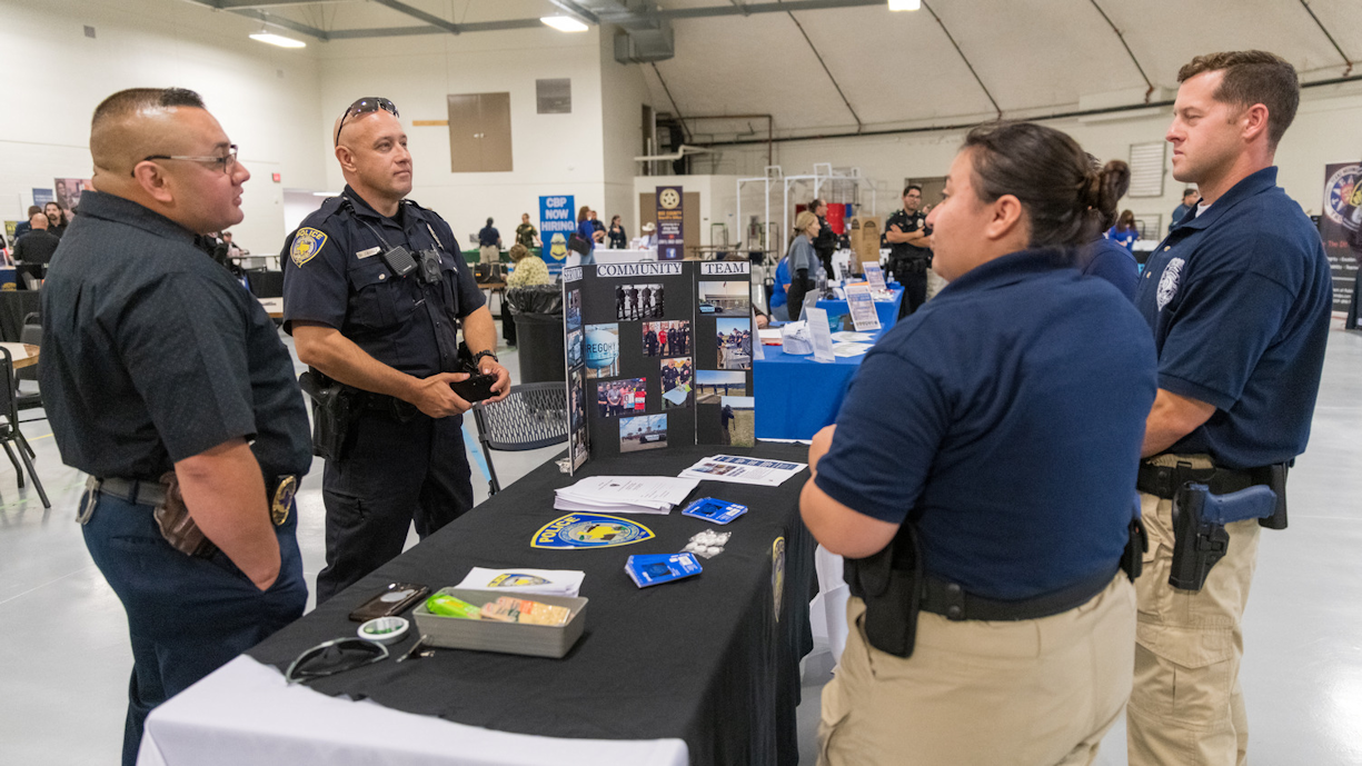 Recruiters discuss job postings with students at career fair