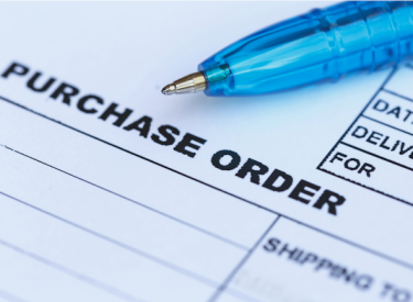 A purchase order document with a pen sitting on top