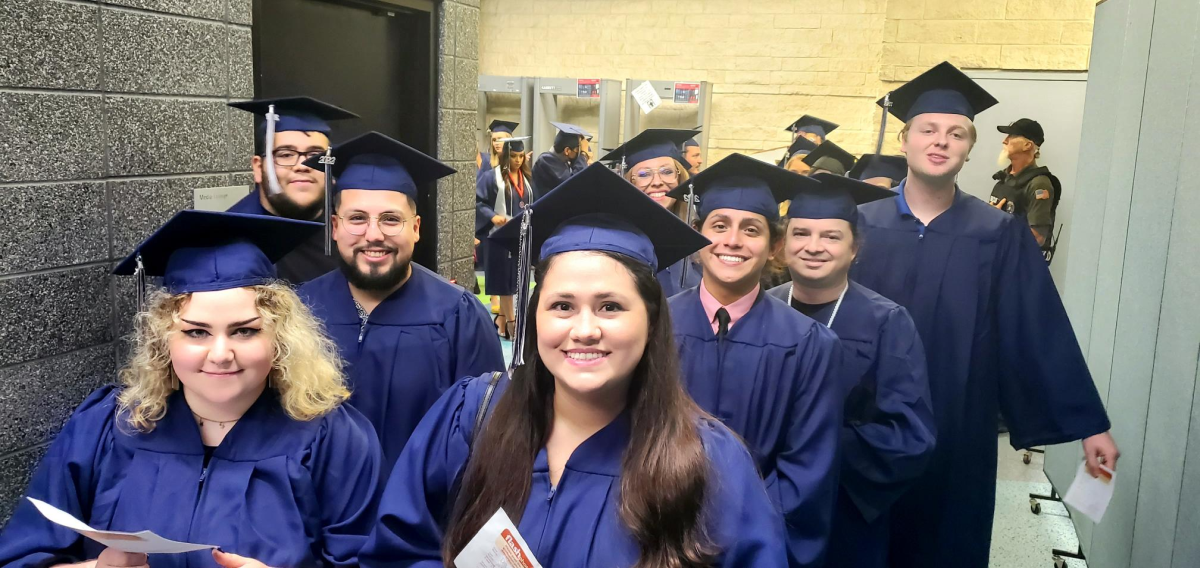 A group of graduates standing in a hallway.
