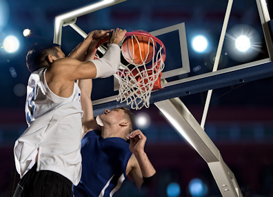 Two guys jumping for the ball at the basketball hoop