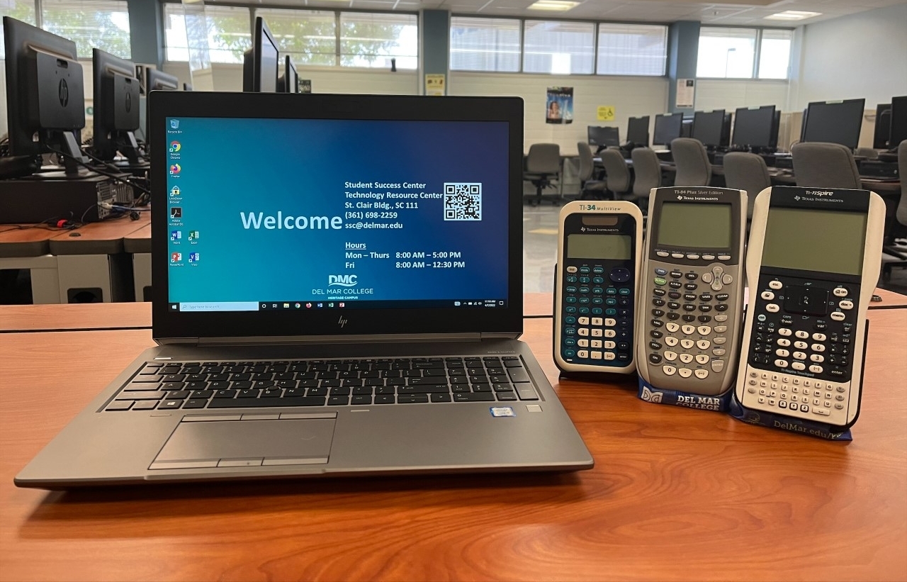A laptop, laptop bag, and a variety of calculators displayed on a desk in the TRC