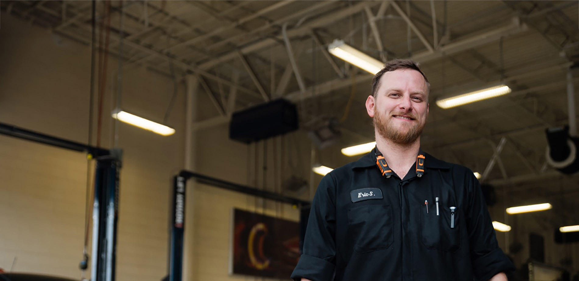 DMC Graduate Eric Stern standing in his auto repair garage